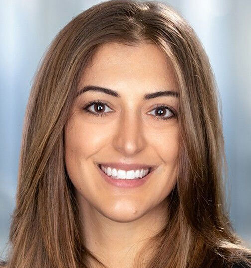 Gina Tuccio, a woman with long brown hair, smiling at the camera.